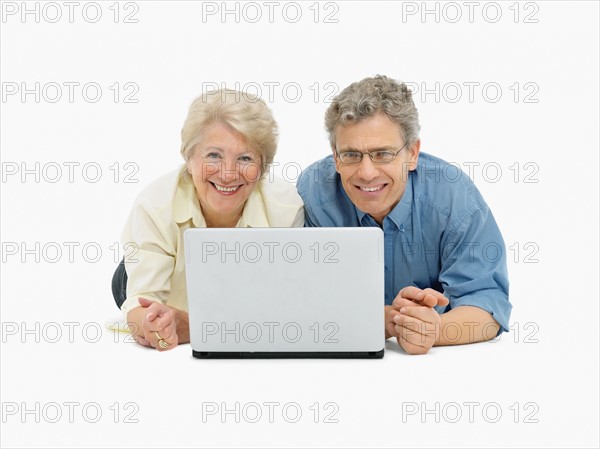 Retired couple looking at laptop together. Photo : momentimages