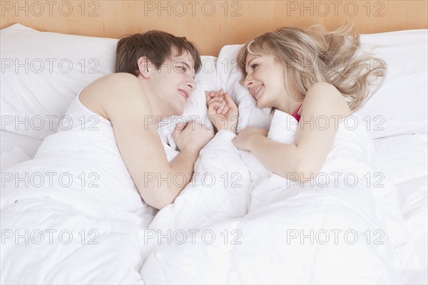 Couple lying in bed together. Photo : Take A Pix Media
