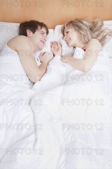 Couple lying in bed together. Photo : Take A Pix Media