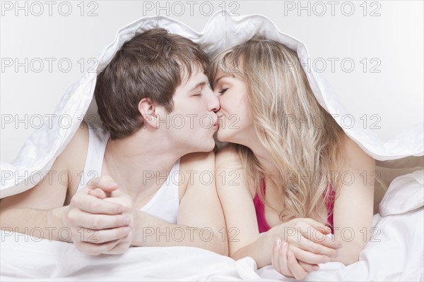 Couple kissing under the covers. Photo : Take A Pix Media