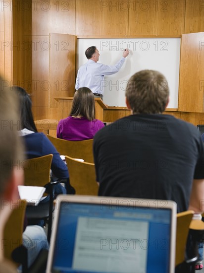 College professor giving lecture in lecture hall.