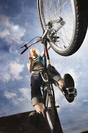 Teenage girl doing a bike trick. Photo : Stewart Cohen