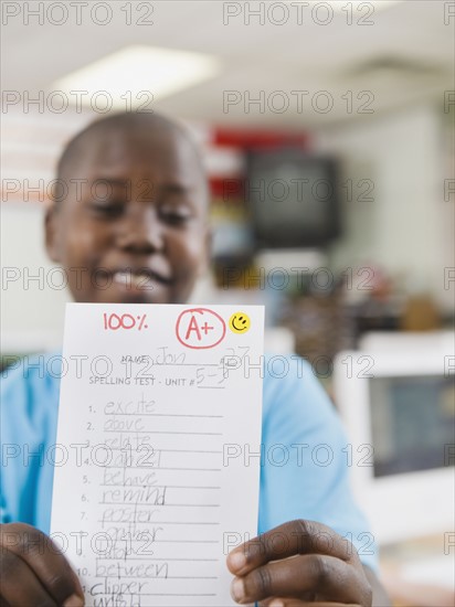 Elementary student holding an A grade paper.