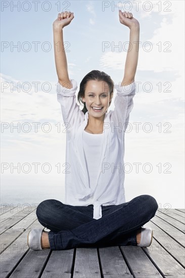 Happy woman sitting on porch. Photo : momentimages