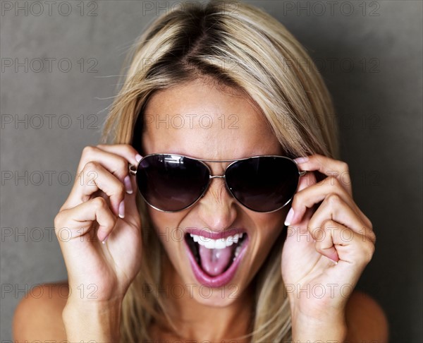 Beautiful blond woman wearing sunglasses. Photo : momentimages