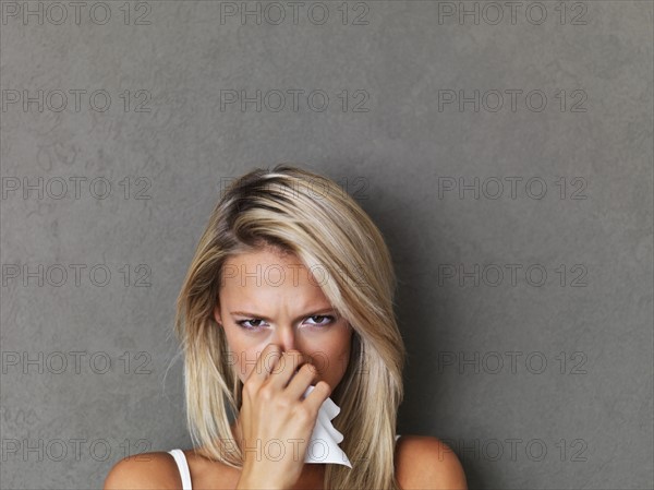 Blond woman holding a handkerchief. Photo : momentimages