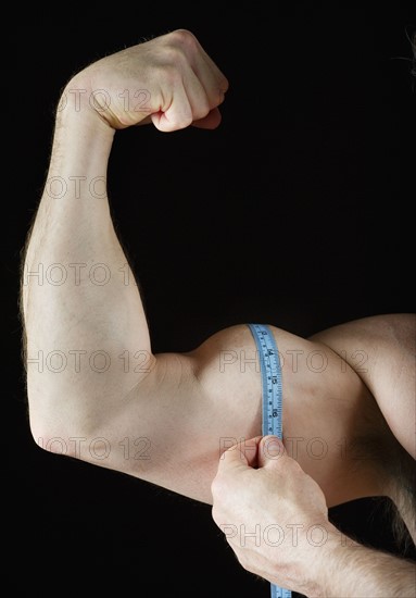 Man measuring his bicep. Photo : Daniel Grill