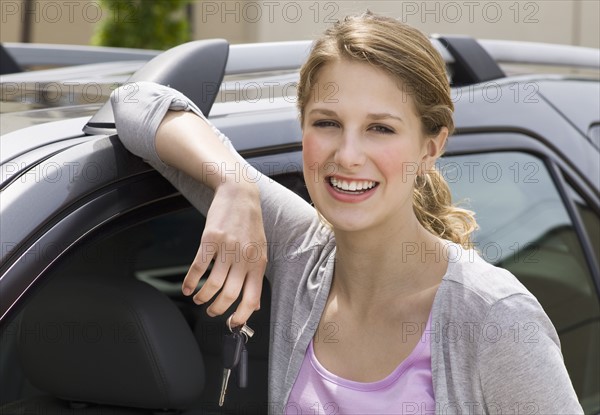 Woman leaning against her new car.