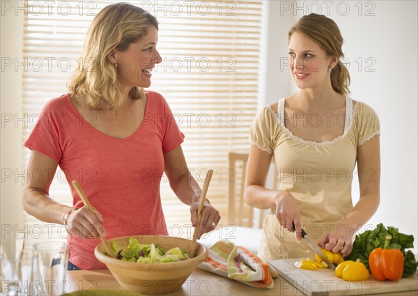 Two women preparing salad.