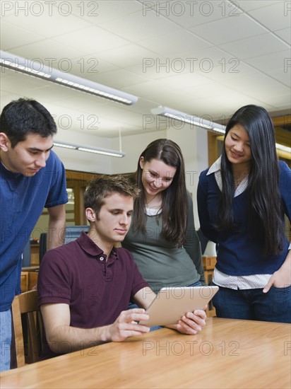 College students looking at electronic book.