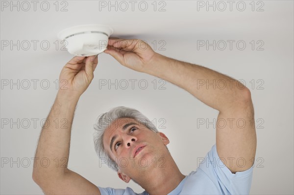 Man testing smoke detector.