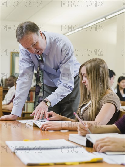 Professor giving instruction to college student.