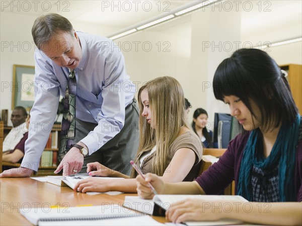 Professor giving instruction to college student.