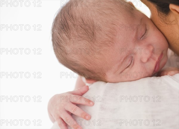 Baby sleeping on mother's shoulder.