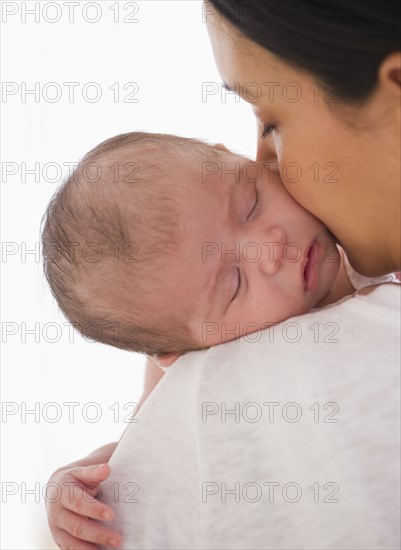 Baby sleeping on mother's shoulder.