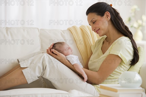 Mother sitting on couch with her baby.