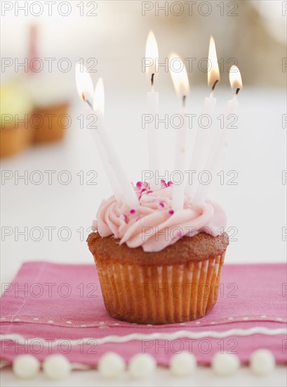 Lit candles on cupcake. Photo : Jamie Grill