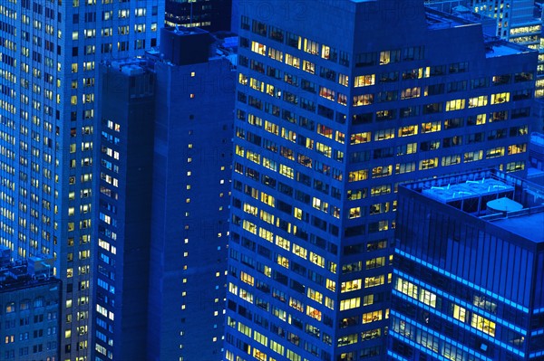 Illuminated buildings in New York City at sunset.