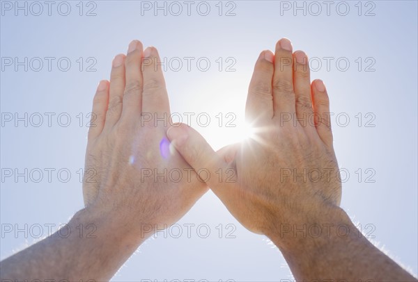 Hands framing sunshine.