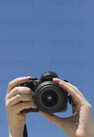 Hands holding a digital camera.