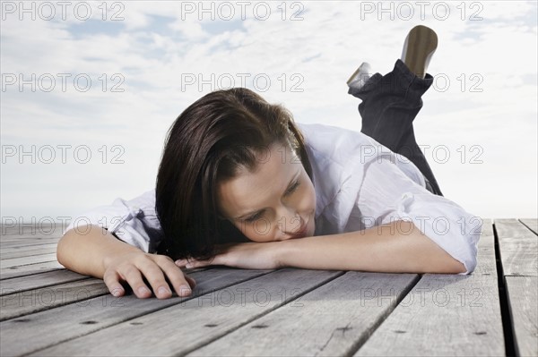 Brunette woman relaxing on porch. Photo : momentimages