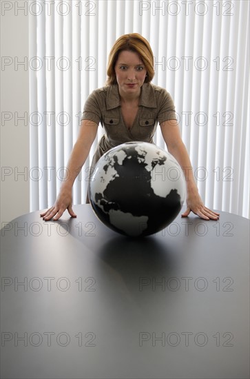 Businesswoman looking at globe.