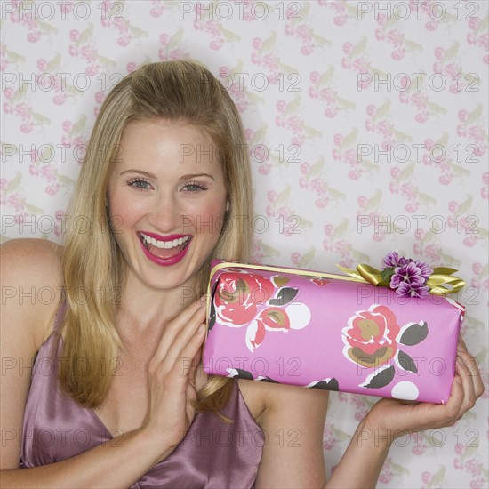 Excited woman holding a gift.