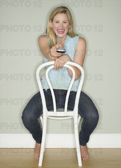 Happy woman holding a remote control.