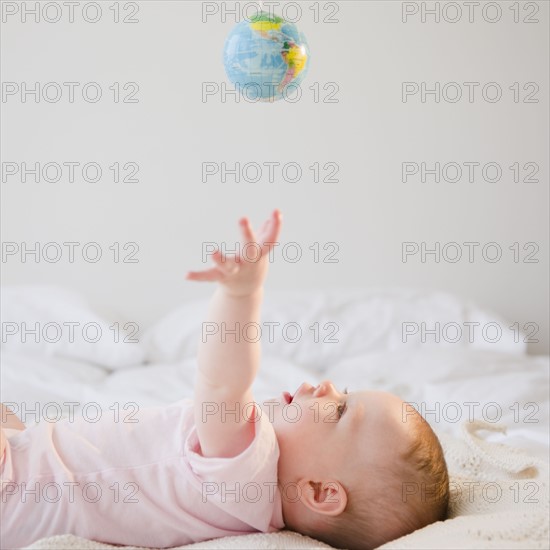 Baby reaching for globe. Photo. Jamie Grill