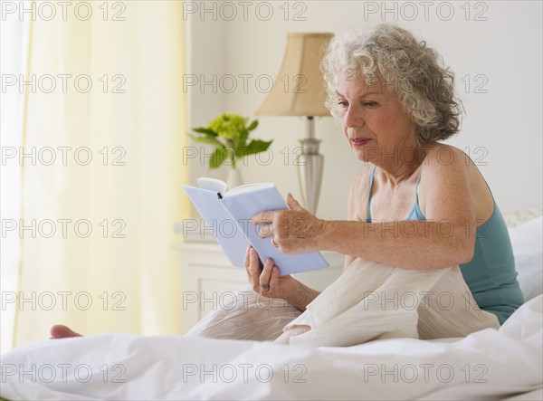 Woman reading in bed. Photo : Daniel Grill