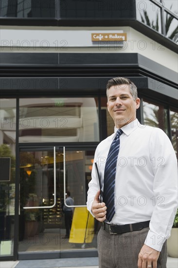 Businessman standing in front of building.