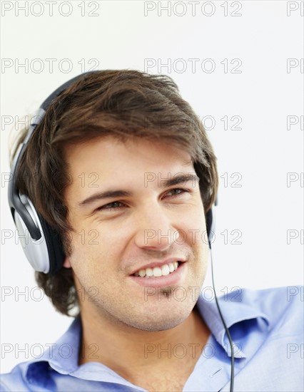 Man listening to music on headphones. Photo : momentimages