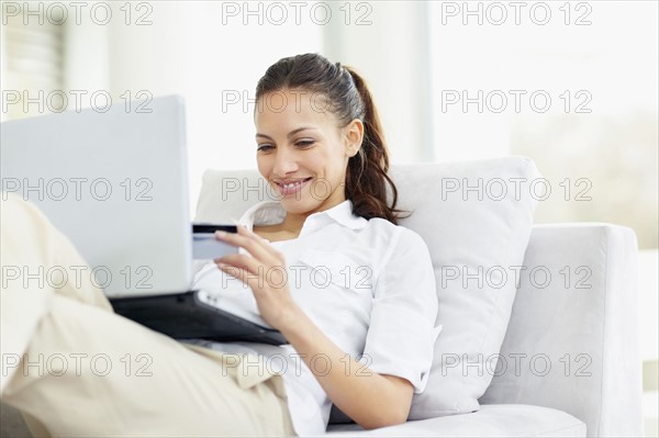 Woman shopping online. Photo : momentimages
