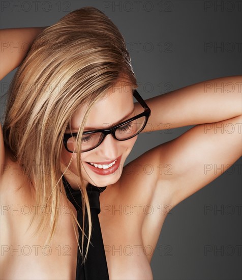 Blond woman wearing only a necktie. Photo : momentimages