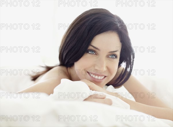 Sexy woman lying on bed. Photo : momentimages