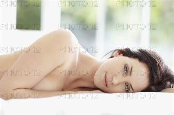 Sexy woman lying on bed. Photo : momentimages