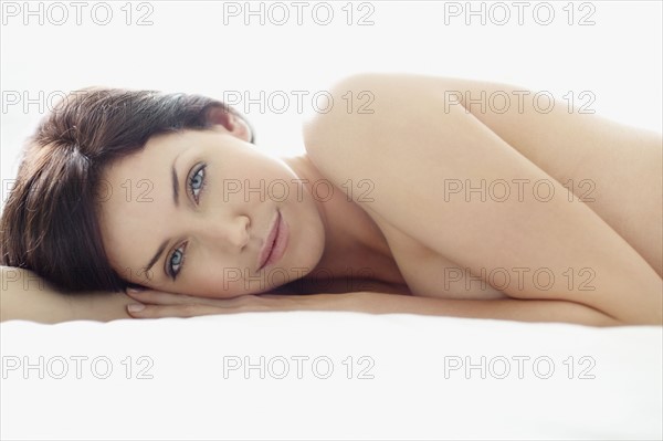 Sexy woman lying on bed. Photo : momentimages