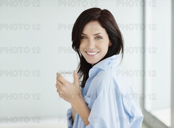 Attractive brunette drinking coffee. Photo. momentimages