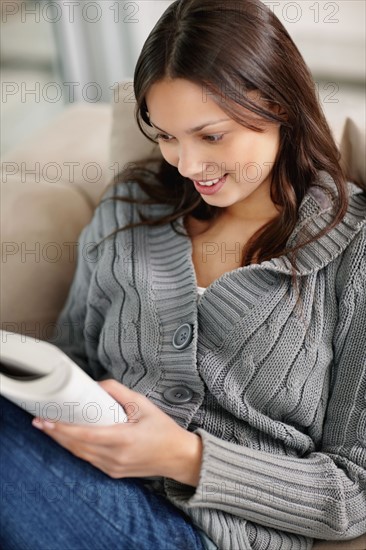 Brunette woman relaxing and reading. Photo : momentimages