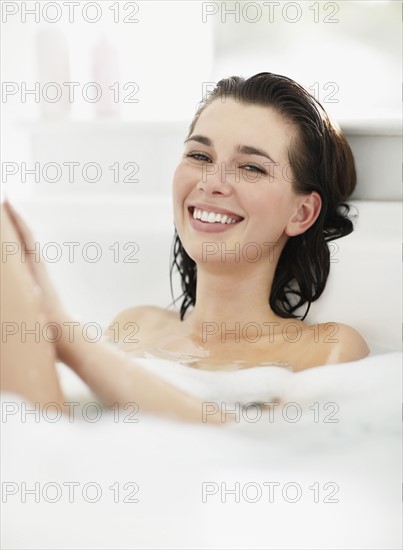 Woman relaxing in bathtub. Photo : momentimages