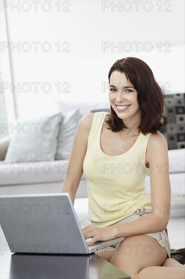 Smiling brunette woman browsing the internet. Photo. momentimages