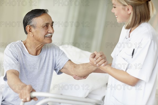 Nurse assisting patient with a walker. Photo. momentimages