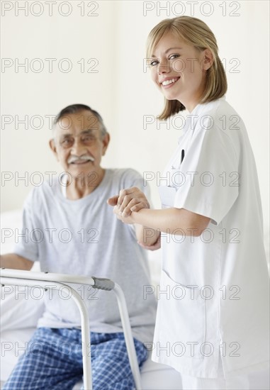 Nurse assisting patient with a walker. Photo : momentimages