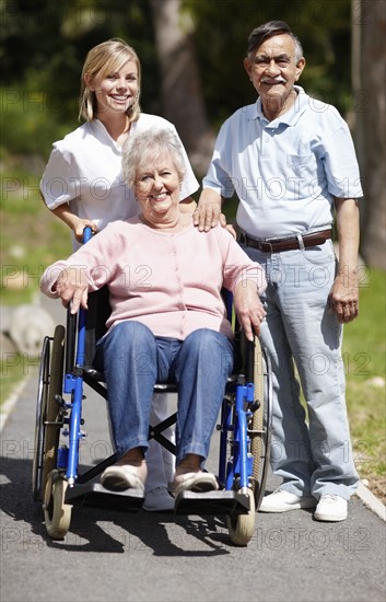 Nurse pushing senior woman in a wheelchair. Photo. momentimages