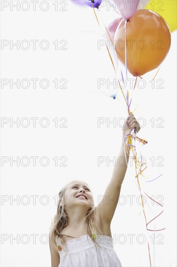 Young girl holding balloons. Photo. momentimages