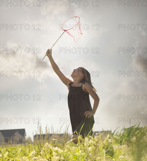 Young girl running with a butterfly net. Photo. Mike Kemp