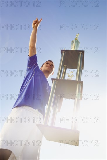Football player holding trophy. Photo : Mike Kemp