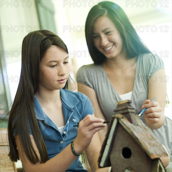 Mother and daughter painting a birdhouse. Photo : Tim Pannell