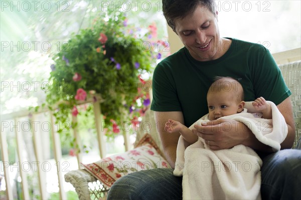 Father sitting on porch with his baby daughter. Photo. Tim Pannell