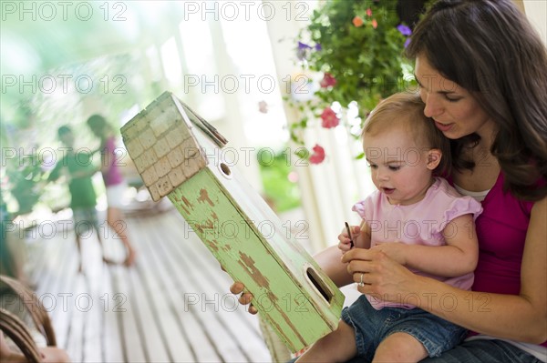 Mother daughter looking at birdhouse. Photo : Tim Pannell